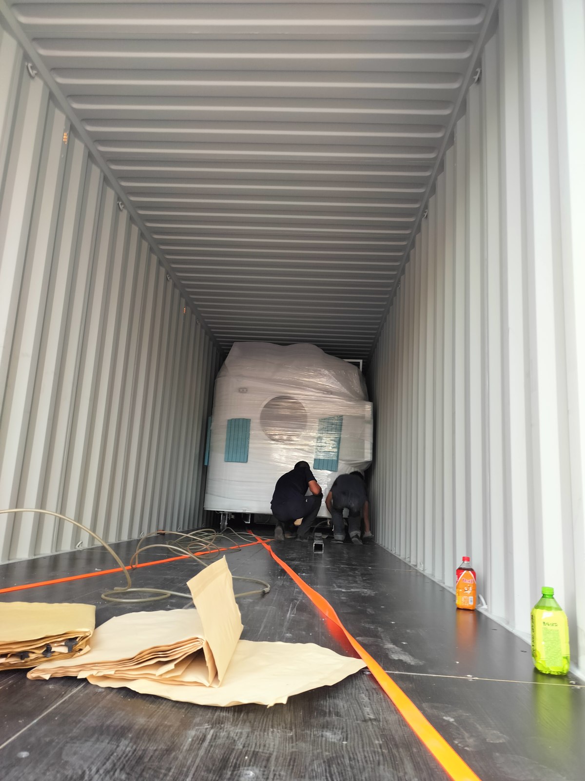 Our team securing a wrapped food trailer inside a shipping container