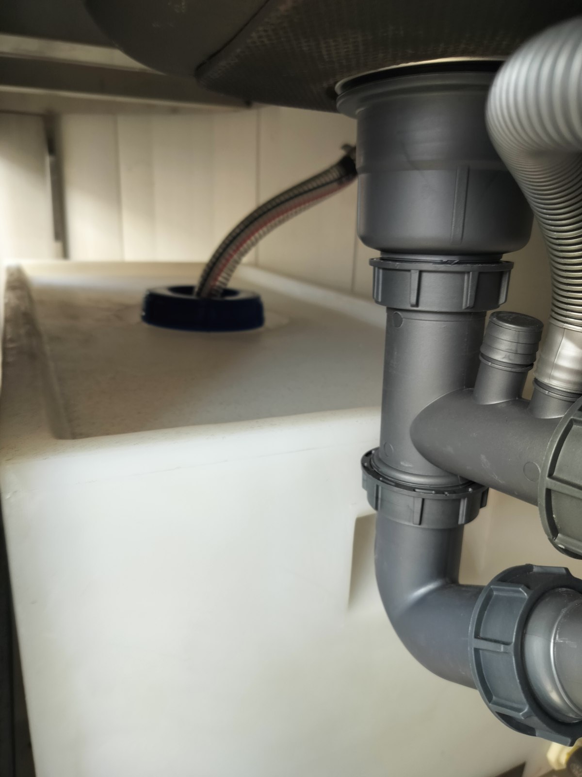 Tank enclosure and surrounding pipework beneath the sink area