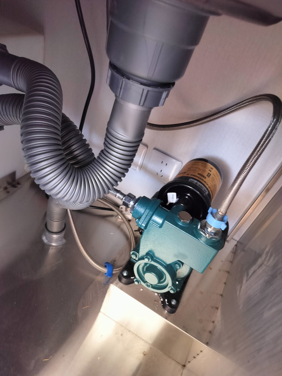 View through the cabinet opening towards the pump and drainage connections