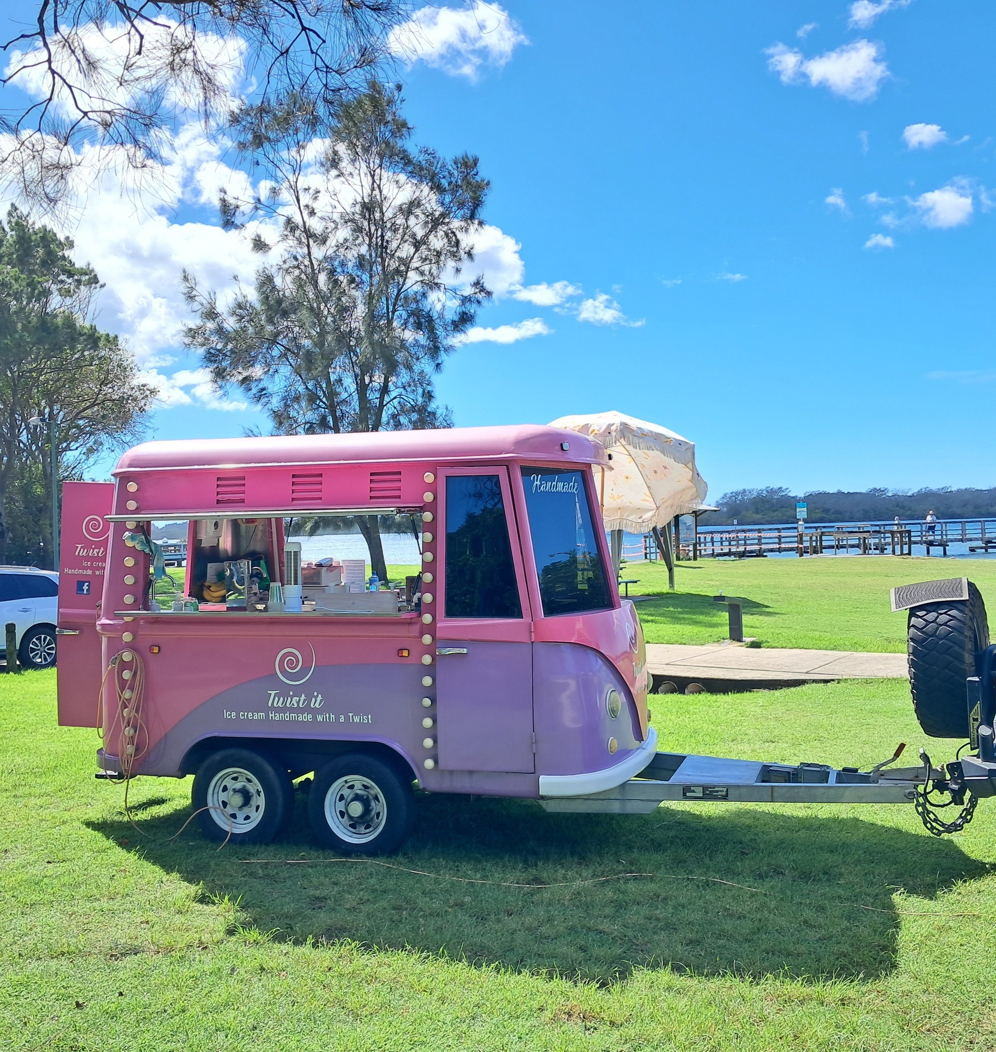 Pink retro-style ice cream trailer operating beside the water in Australia